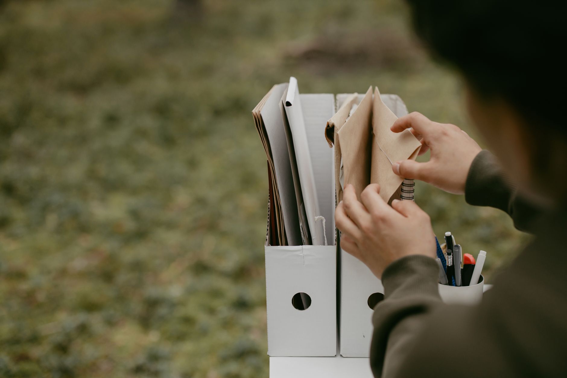 Una persona joven organiza documentos médicos y revisa información en una computadora portátil antes de una consulta virtual, mostrando un historial médico bien estructurado.