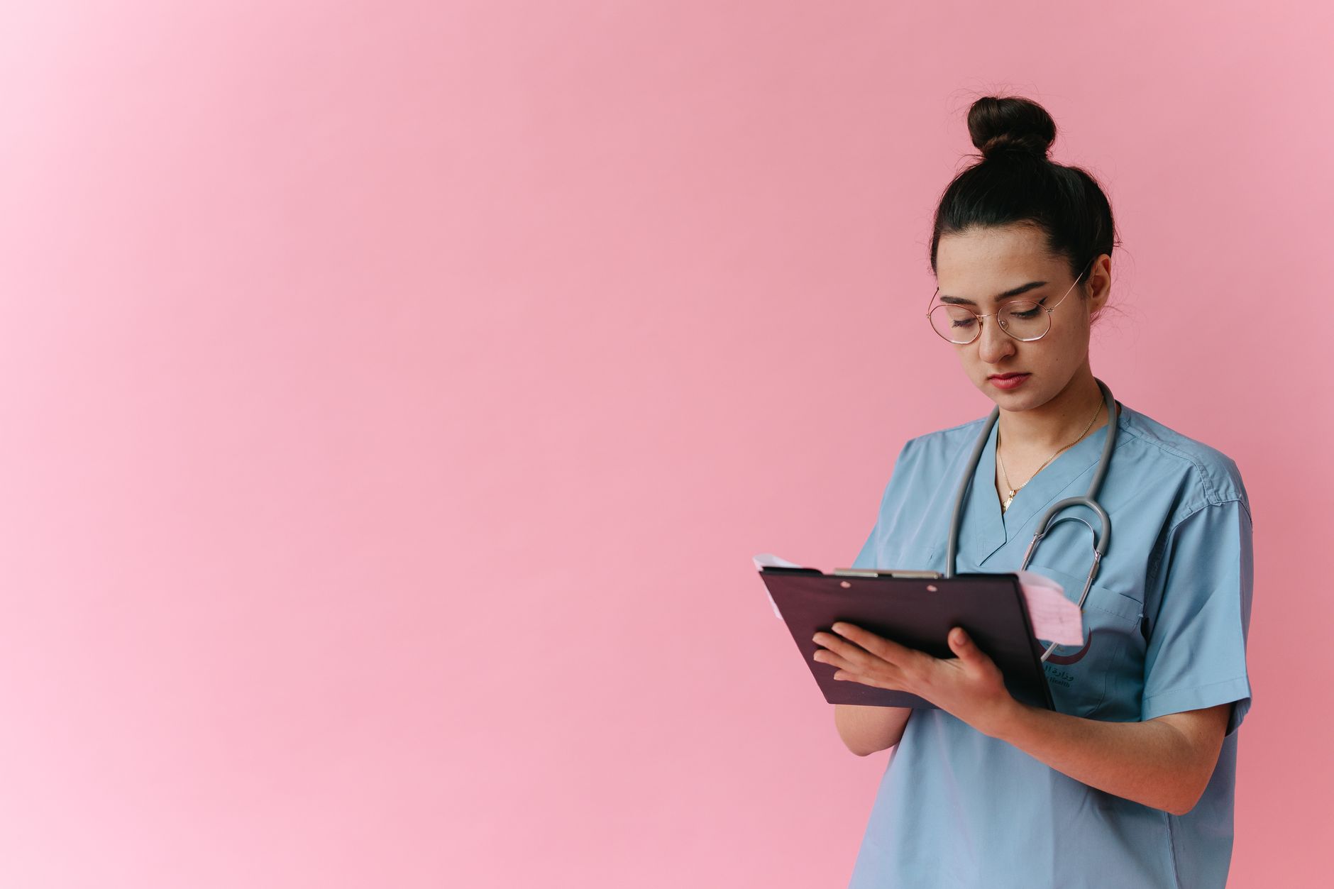 Una persona joven organiza documentos médicos y revisa información en una computadora portátil antes de una consulta virtual, mostrando un historial médico bien estructurado.