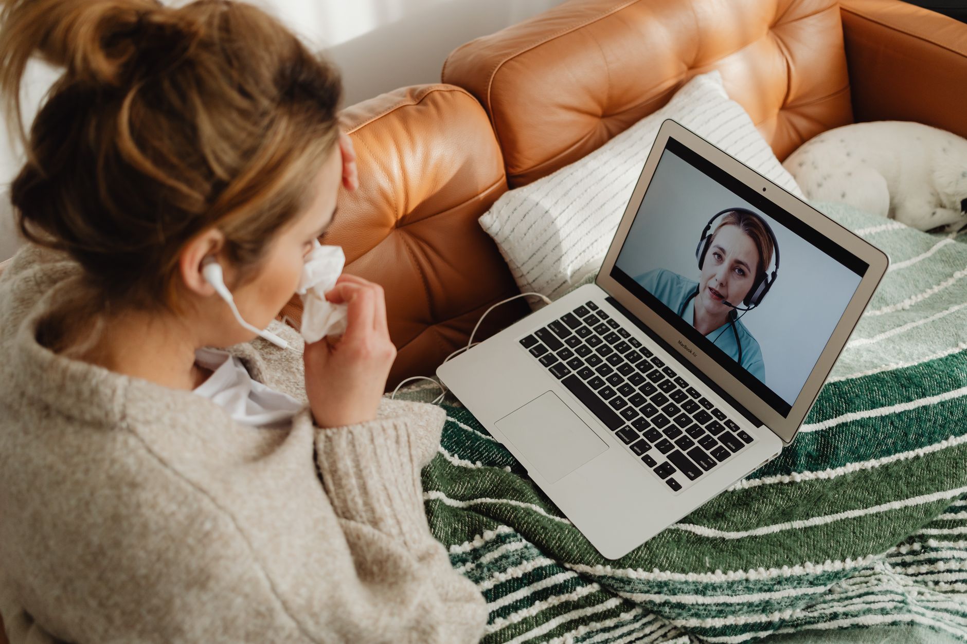 Una persona joven organiza documentos médicos y revisa información en una computadora portátil antes de una consulta virtual, mostrando un historial médico bien estructurado.
