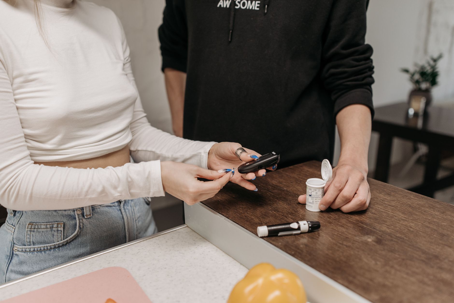 Persona revisando sus registros de glucosa en una tablet, preparándose para una consulta virtual con su médico