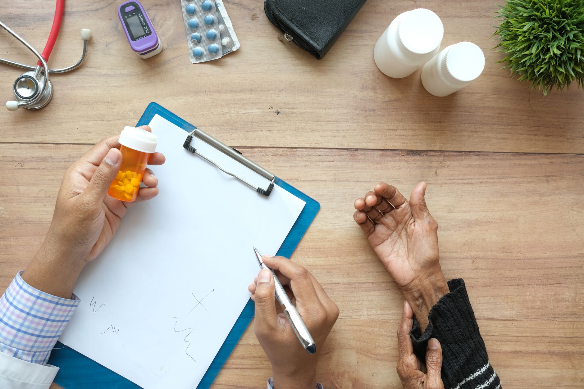 Una persona joven revisando una lista de medicamentos en su teléfono o tableta, con un fondo borroso de un hogar acogedor, preparándose para una consulta médica virtual.