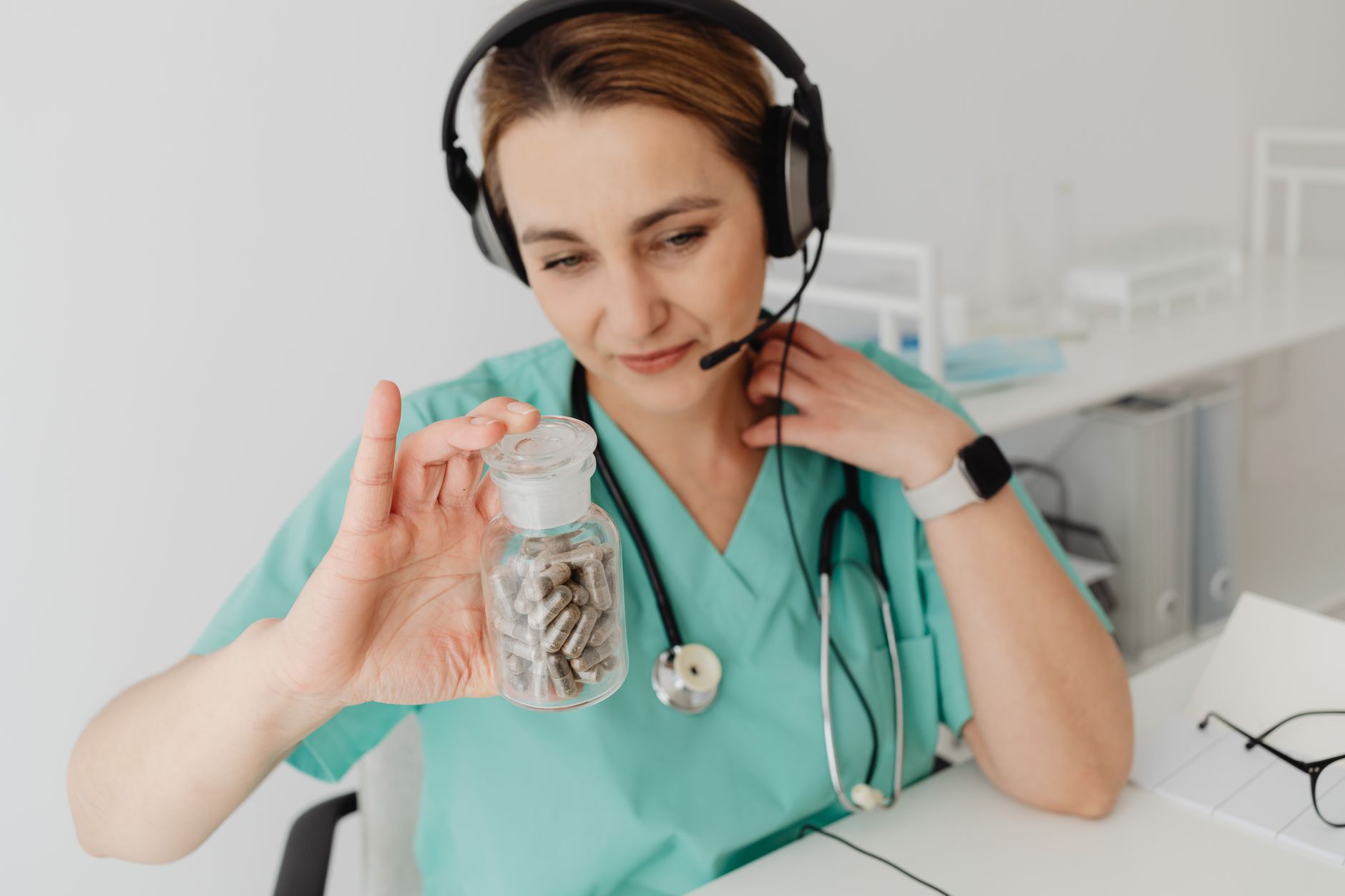 Persona organizando sus medicamentos en un pastillero antes de una videollamada de consulta médica virtual