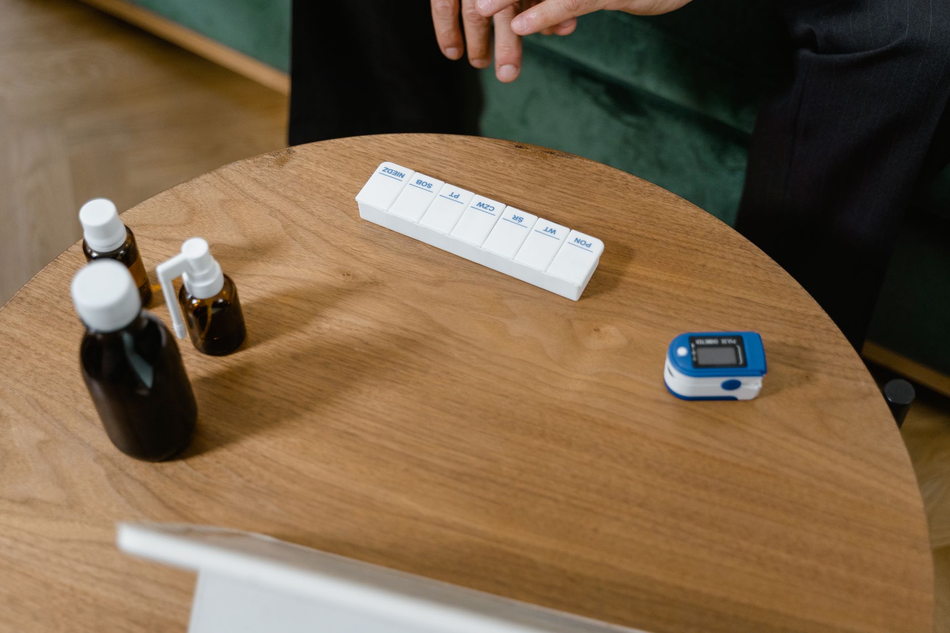 Persona organizando sus medicamentos en un pastillero antes de una videollamada de consulta médica virtual