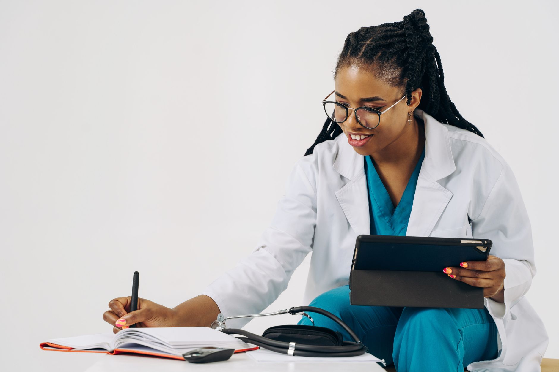 Una persona joven y atenta haciendo una videollamada con un médico, con una libreta y lápiz a su lado, simbolizando una consulta médica online bien preparada.