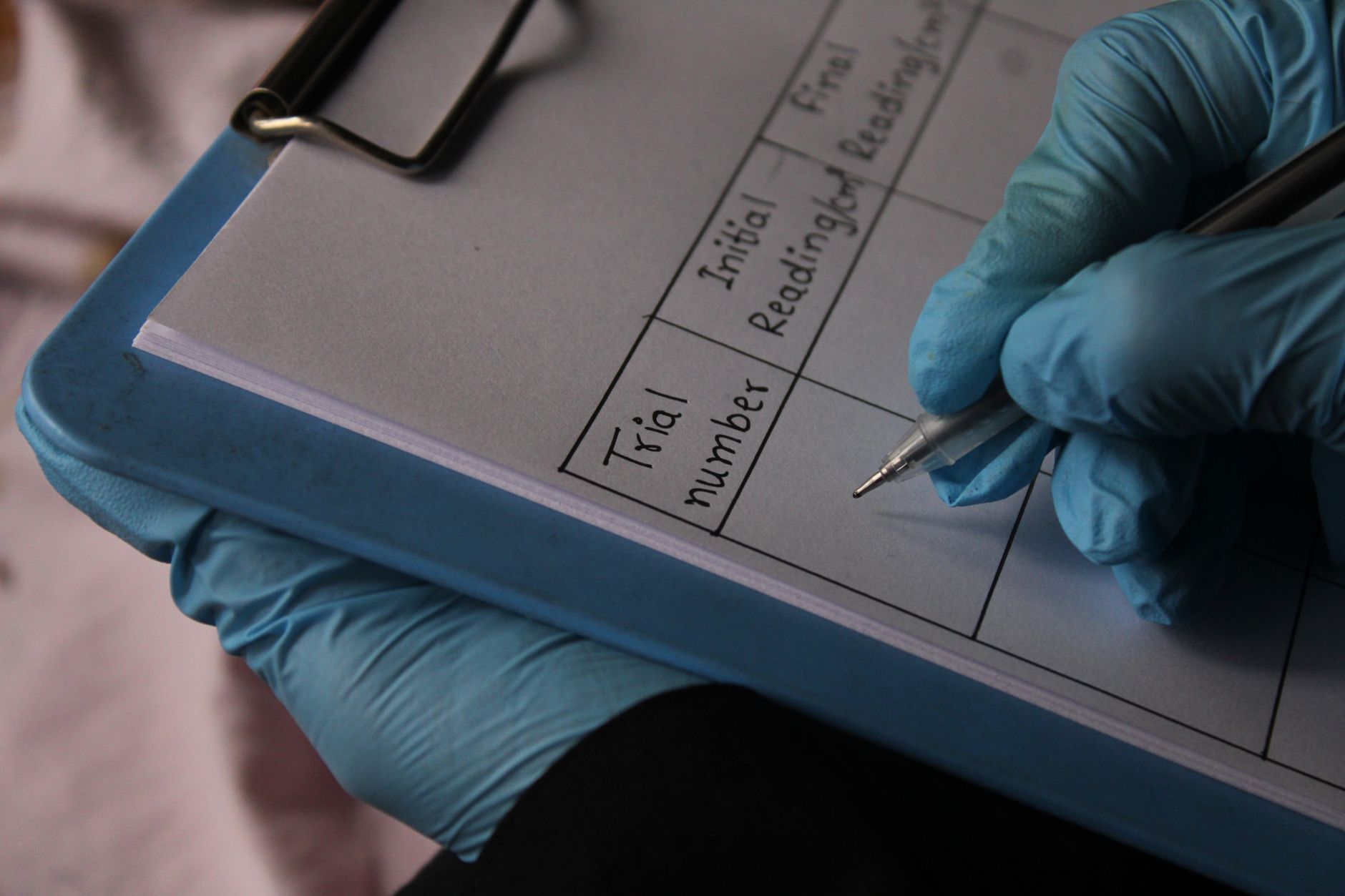 Una persona joven organizada revisando documentos médicos y resultados de laboratorio en una tableta antes de una consulta virtual, con una taza de café al lado.