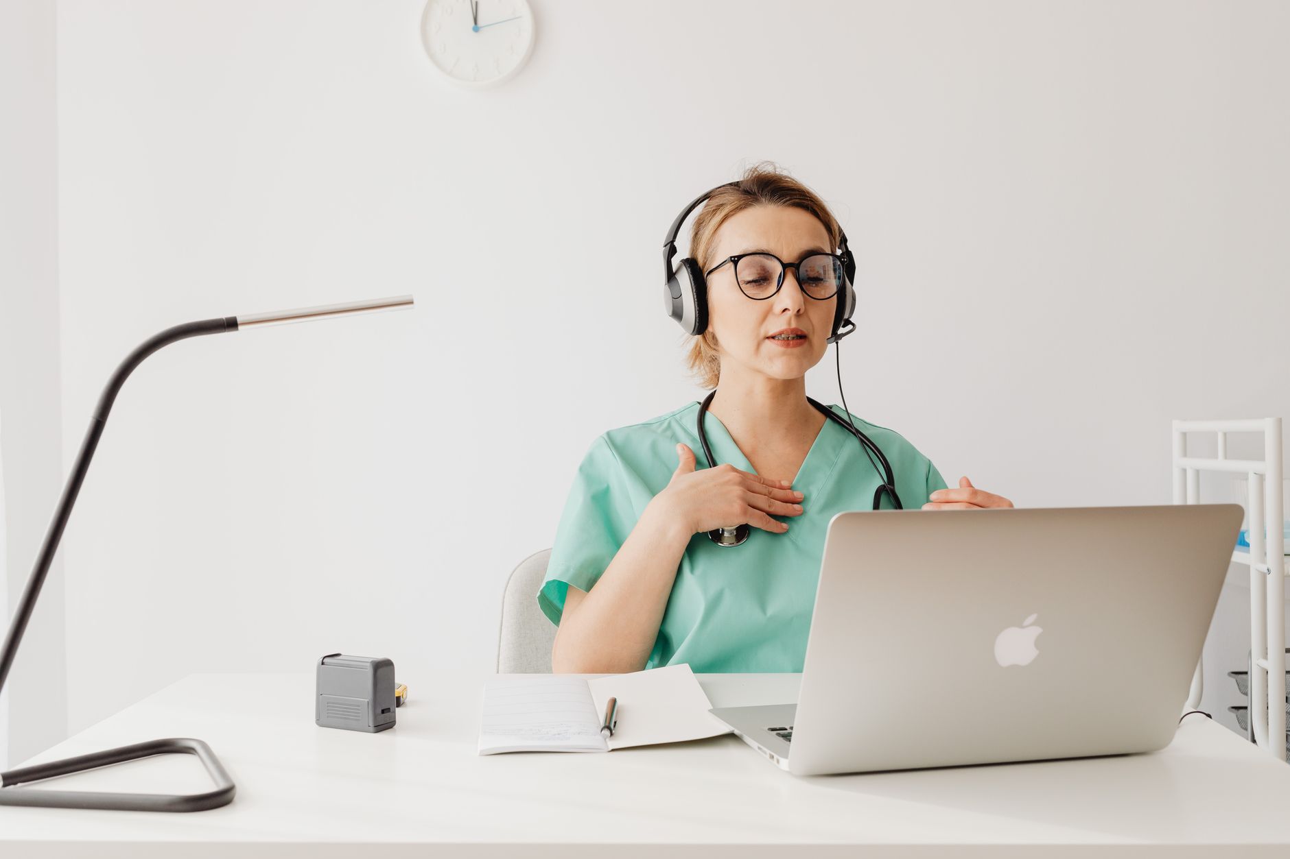 Una persona joven concentrada, usando audífonos y una laptop en un entorno tranquilo y privado, simbolizando una consulta médica virtual segura y confidencial.